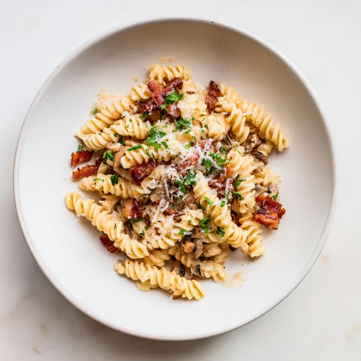 Golden fusilli with bacon, onions, and mushrooms, a comforting Italian pasta dish ready in 30 minutes.