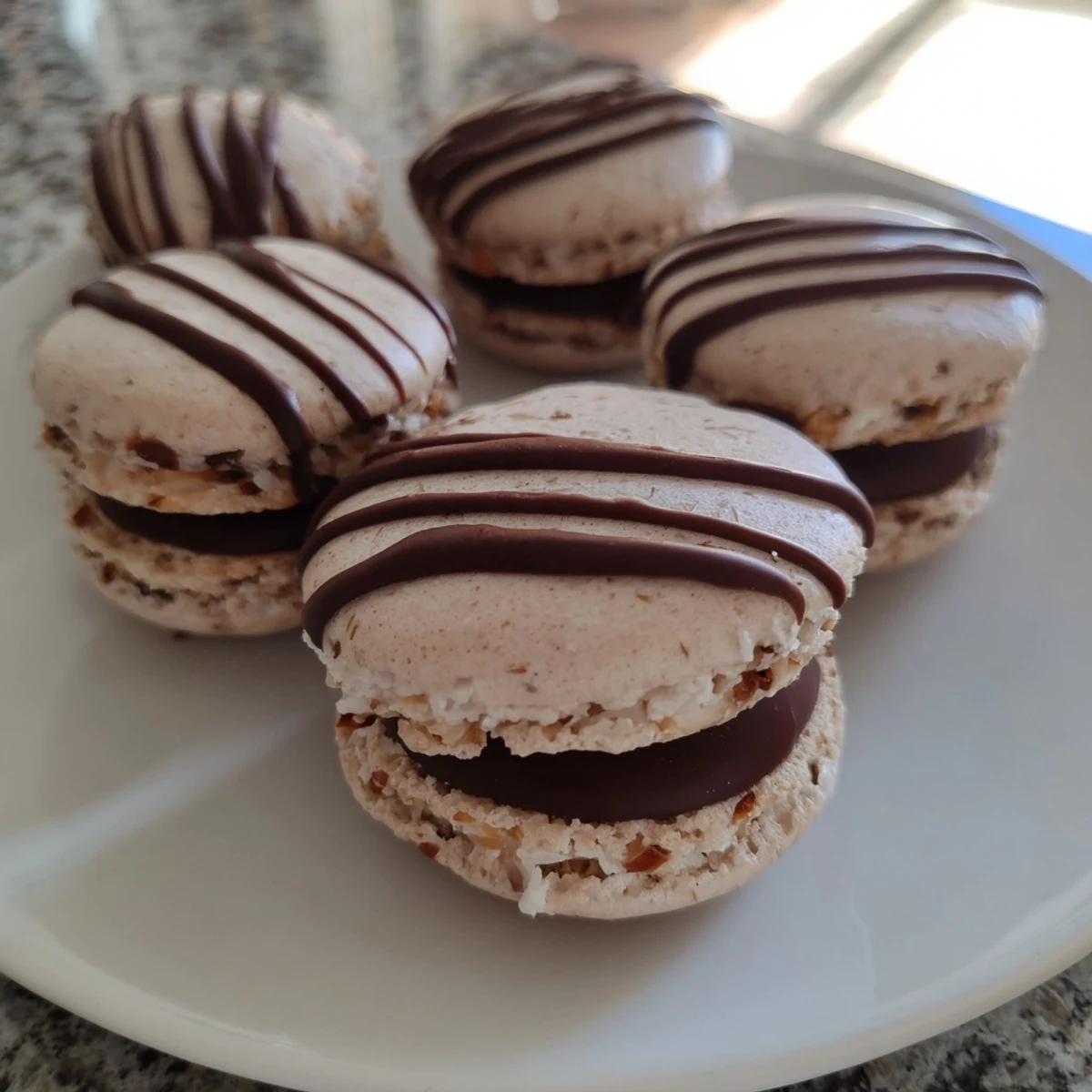 Fluffy, white 5-Minute Coconut Macaroons, ready to eat, with a drizzle of melted dark chocolate.