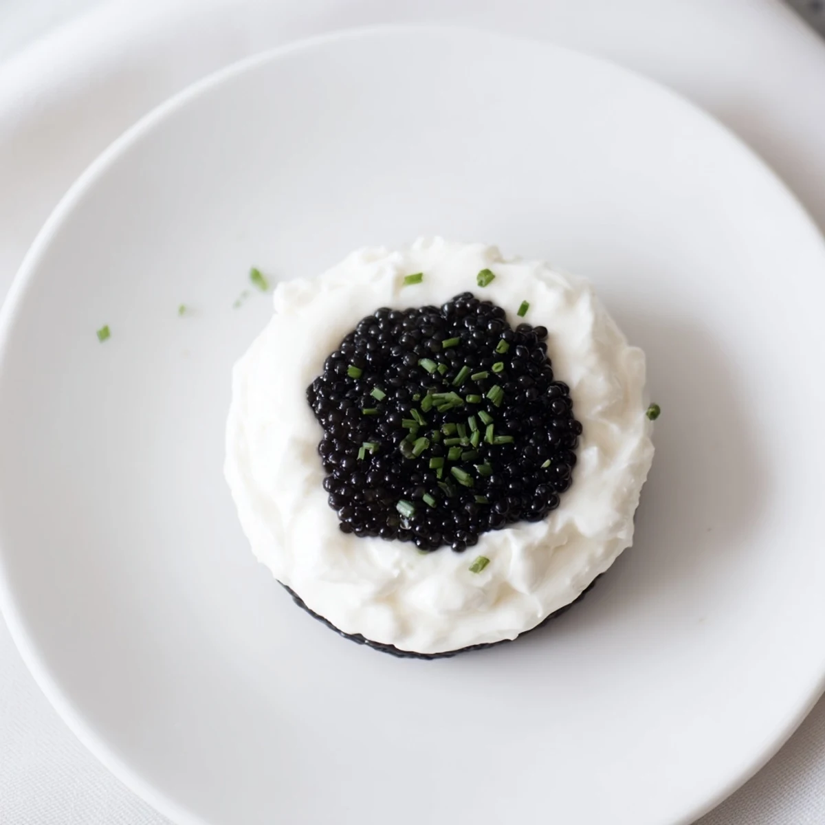Elegant Diamond Inlay appetizer: a luxurious caviar center inside a creamy ring served on crackers.