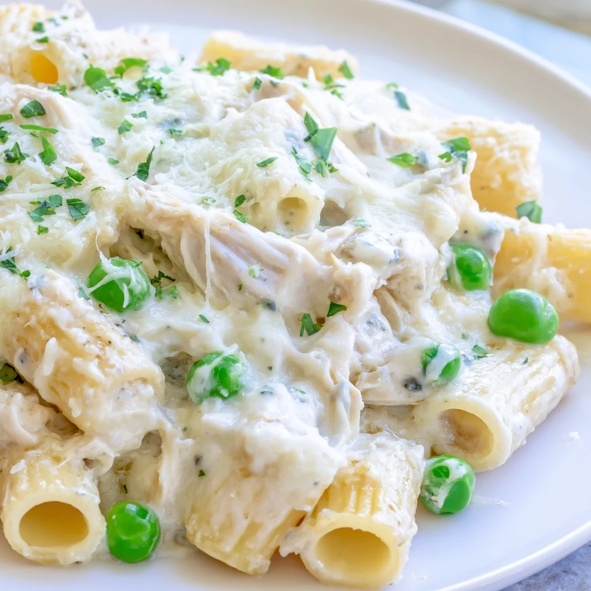 Delicious slow cooker chicken Alfredo pasta bake, with herbs, presenting a perfect comfort food meal.