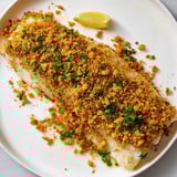 Close-up of golden baked cod, showing the flaky fish and buttery cracker crust's textures.