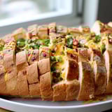 This vibrant image shows a baked Pimento Cheese & Jalapeño Pull-Apart Grilled Cheese, ready to be shared.