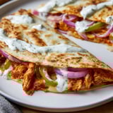 A close-up shot of a deliciously cheesy Tandoori Chicken Quesadilla, perfectly cooked and flavorful.