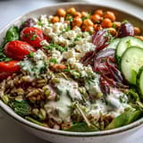 Close-up shot of a Mediterranean Farro Bowl featuring feta crumbles, Kalamata olives, and fresh parsley garnish.