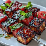 Juicy watermelon and savory halloumi skewers, hot off the grill, topped with mint.