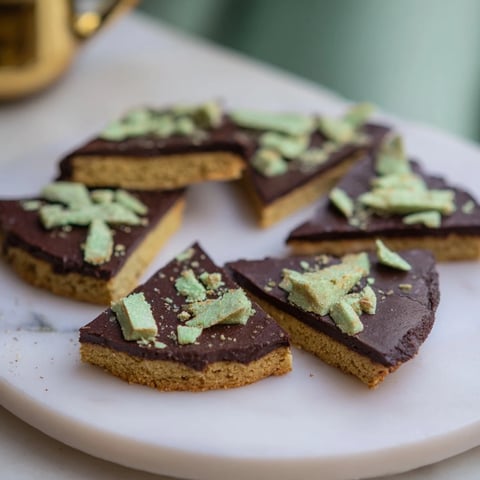 Warm chocolate peppermint shortbread wedges arranged on a cooling rack, perfect for holiday baking enjoyment.