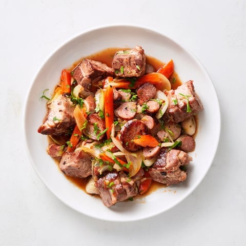 Steaming bowl of spicy Sriracha Bigos Fusion: a hearty winter stew with chunks of meat.