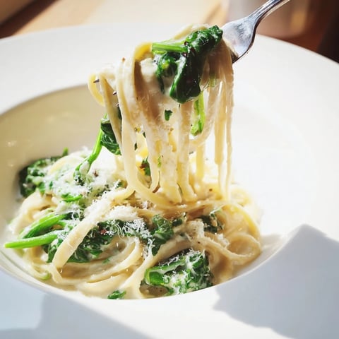 Steaming Creamy Greek Yogurt Spinach Alfredo Pasta, a comforting pasta dish with fresh spinach and Parmesan cheese.