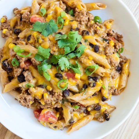 Steaming bowl of Cheesy Taco Pasta with melted cheese and fresh cilantro, ready to serve.