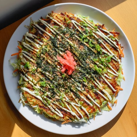 Golden-brown Japanese Okonomiyaki Pancakes sizzling in a skillet, topped with bonito flakes dancing from the steam and creamy mayo drizzle.  
