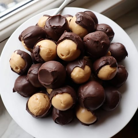 Close-up of luscious 3-ingredient Peanut Butter Balls, coated in dark chocolate, a perfect bite.