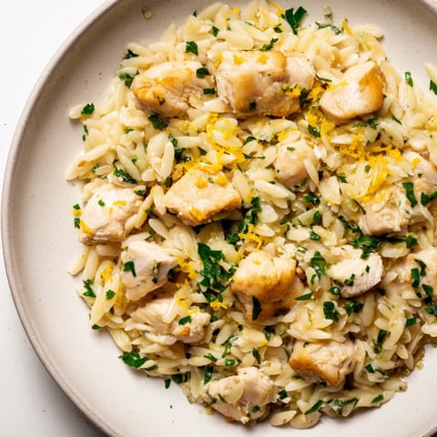 Sizzling Creamy Lemon Chicken Orzo served in a bowl, showing saucy orzo and flavorful chicken pieces.