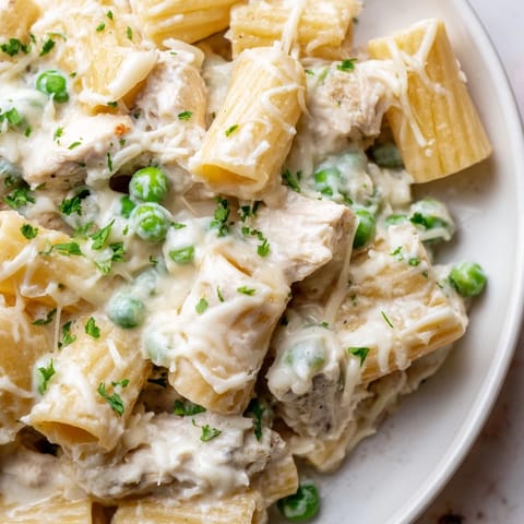 A close-up shot of creamy slow cooker chicken Alfredo pasta bake, ready to serve and enjoy.