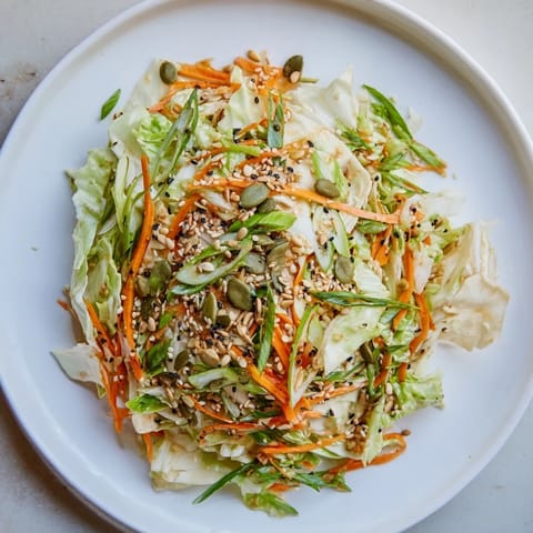 Close-up of a refreshing Cabbage-Core Slaw Salad, ready to serve with toasted seeds sprinkled on top.