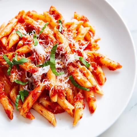 Steaming hot Microwave Bowl Pasta coated in vibrant marinara sauce, ready to eat.