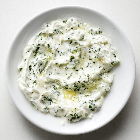 Close-up shot shows light, airy Greek Yogurt Herb Dip, ideal for appetizers and parties.