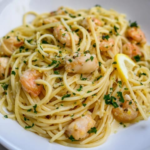 A close-up of Lemon Garlic Shrimp & Chicken Pasta shows glistening pasta strands, sautéed chicken, and succulent shrimp, garnished with fresh parsley and lemon wedges.