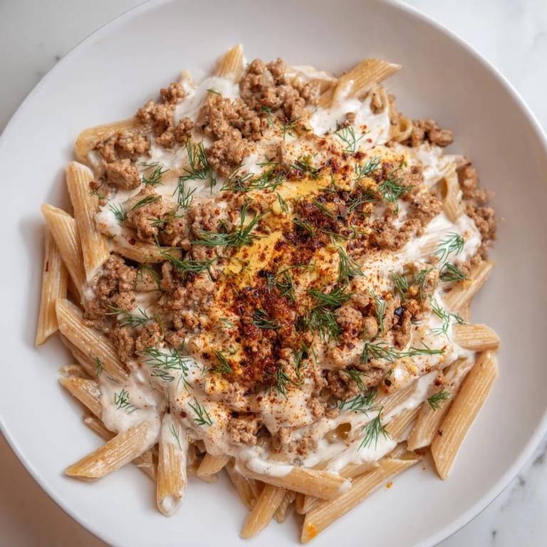 Vivid image of delicious Turkish Pasta with Ground Turkey, creamy yogurt sauce, and a buttery drizzle.