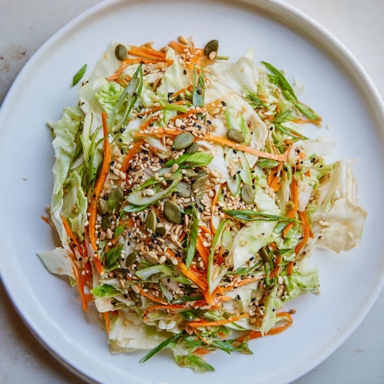 Close-up of a refreshing Cabbage-Core Slaw Salad, ready to serve with toasted seeds sprinkled on top.