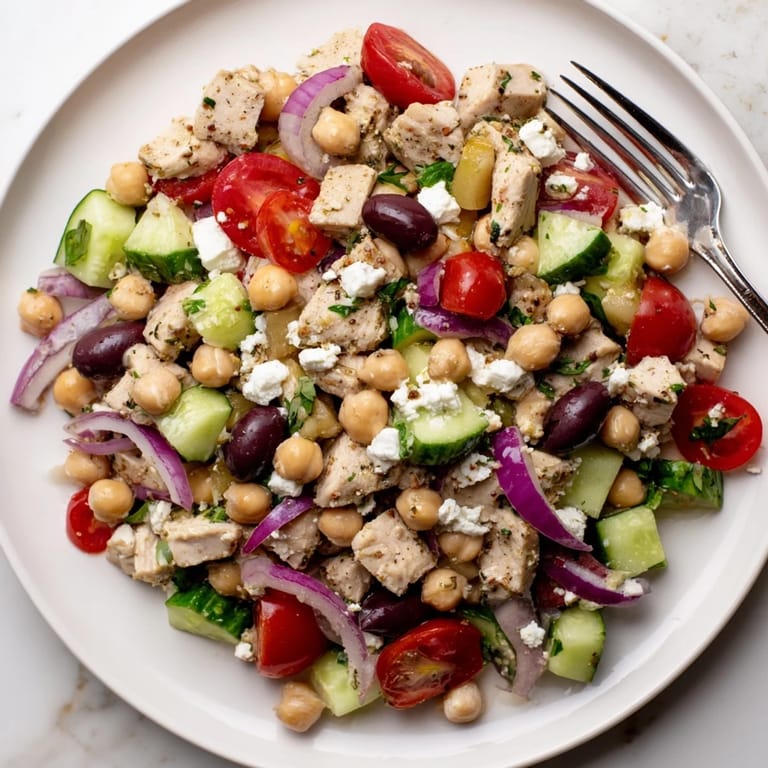 Fresh Mediterranean Chickpea Chicken Salad in a light, zesty lemon-oregano dressing, featuring tender chicken, creamy feta, crisp cucumbers, and briny olives with colorful cherry tomatoes.  